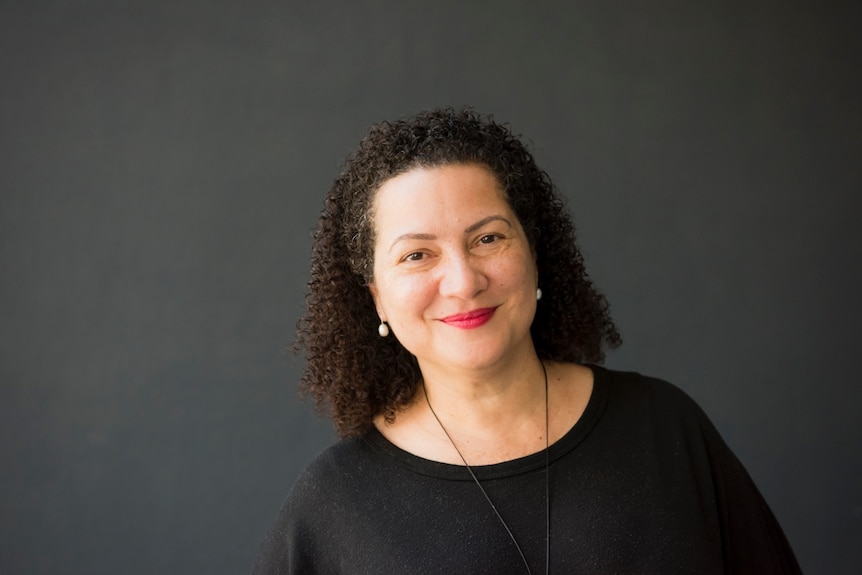 A black-haired woman smiles at the camera