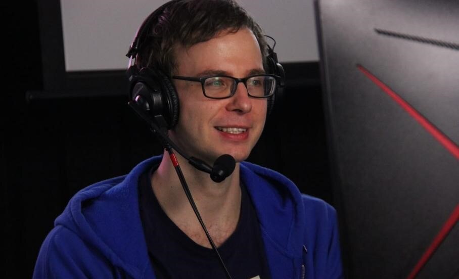 A man wearing a headset in front of a computer 