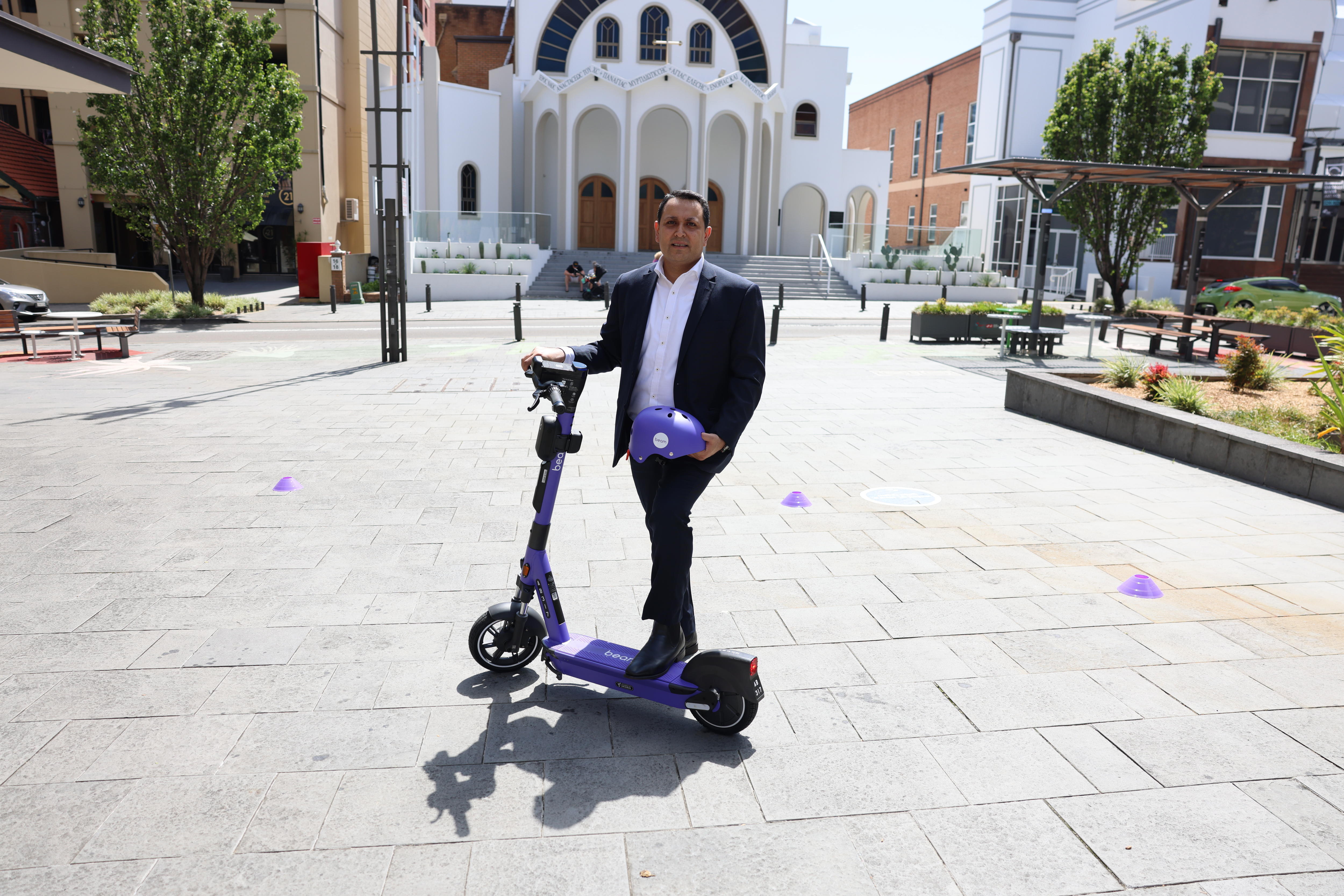 A man on a scooter in a public plaza