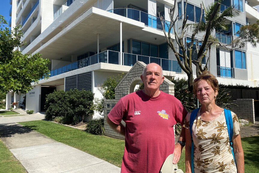 Locals Robert Dove and Bev Hedgers pose for camera in front of apartment where the couple died.
