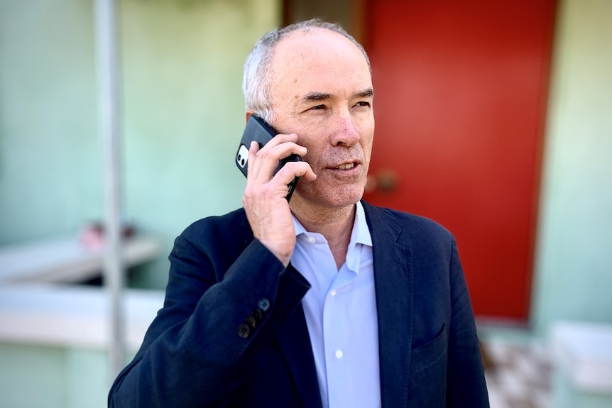 Richard McGregor, senior fellow at the Lowy Institute, using a mobile phone.