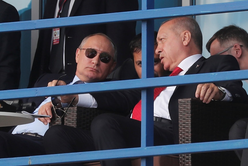 Vladimir Putin and Recep Tayyip Erdogan chatting on some bleachers