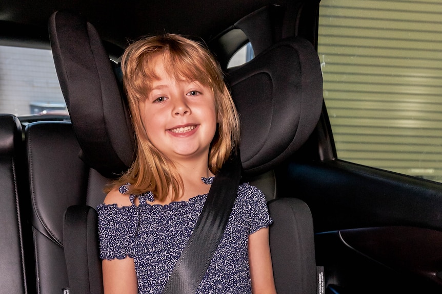 A child wearing a seatbelt,