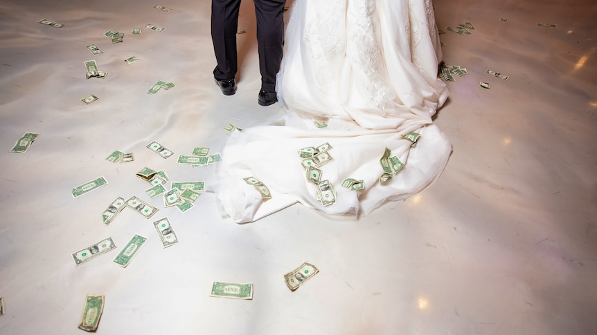 Bride and groom with money on the floor around them.