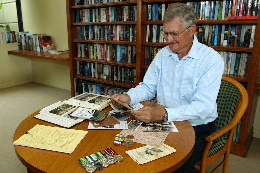 Dr Lindsay McDowell looks at war memorabilia, photos and documents from his grandfather.