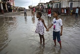 Girls hold hands amid Hurricane Matthew devastation