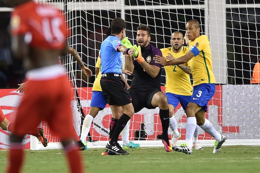 Brazil players remonstrate with referee