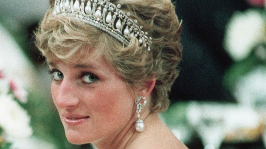 Princess Diana in a low-backed pearl gown and tiara looking over her shoulder