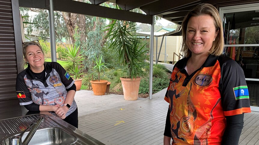 Aboriginal Health Practitioner Kim Moffat and Dietician Susannah Summons standing behind an outdoor kitchen.