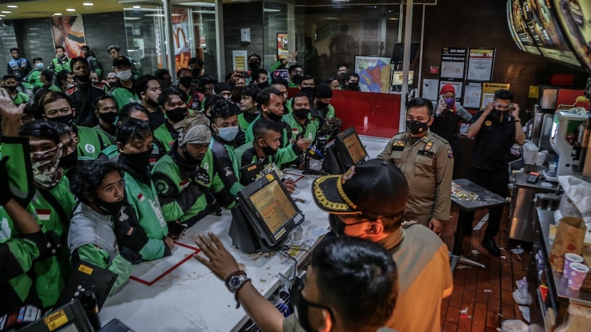 Dozens of food delivery riders queue up at a McDonald’s outlet in Bogor, Indonesia. 