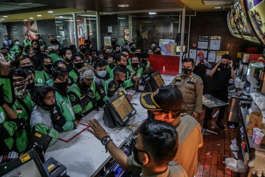 Dozens of food delivery riders queue up at a McDonald’s outlet in Bogor, Indonesia. 