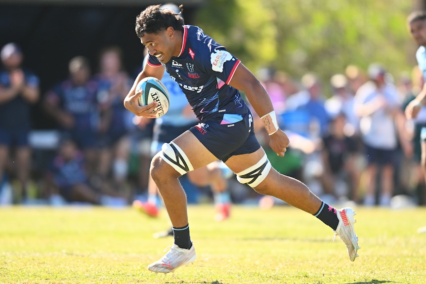 A Melbourne Rebels player runs with the ball during a preseason trial match.