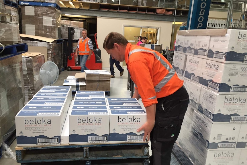 A worker packing water bottles at Beloka Water in Dalgety