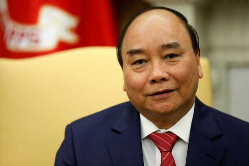 Nguyen Xuan Phuc looks at the camera. He sits in front of a pale yellow background in the Oval Office