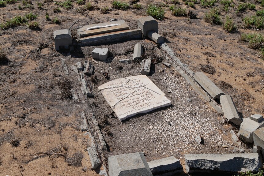Graves against a desert backdrop, all showing visible signs of damage. Several are cracked or split in places.