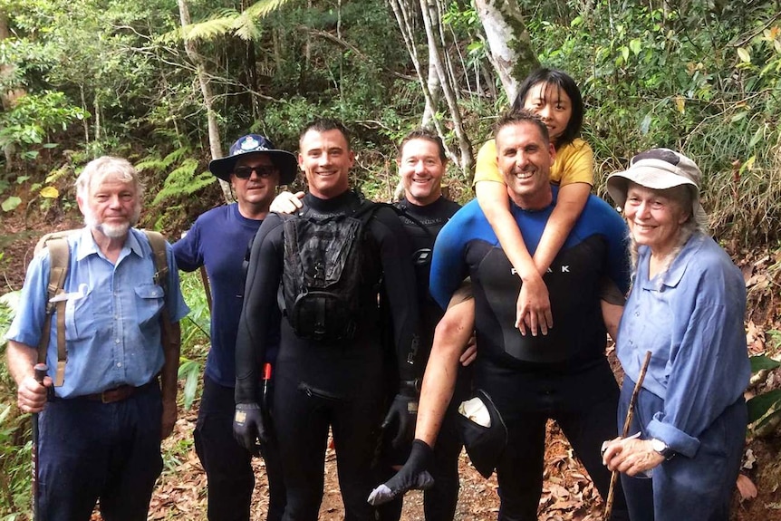 University student Yang Chen, being piggy-backed by one of her rescuers, in a group photo.