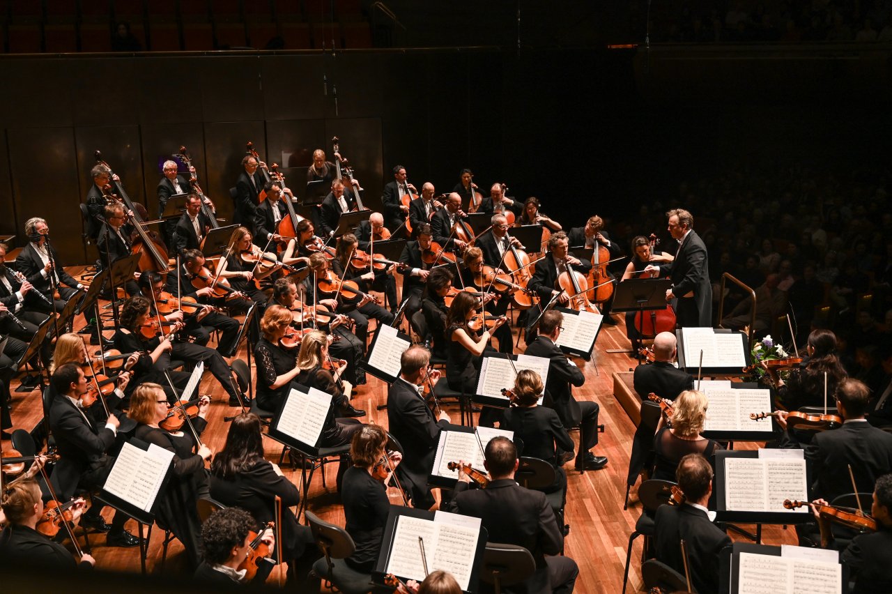 Conductor Alexander Briger conducts the Australian World Orchestra on stage at Hamer Hall.