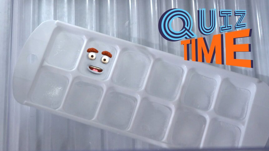An ice cube tray filled with ice. One ice cube has a smiling cartoon face on it.