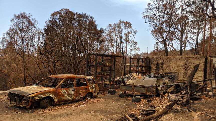 A burnt out car in a burnt out yard a few weeks after the Malua Bay bushfires