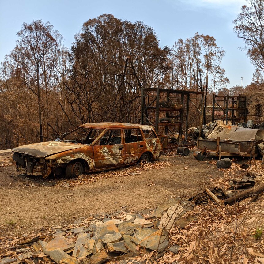 A burnt out car in a burnt out yard a few weeks after the Malua Bay bushfires