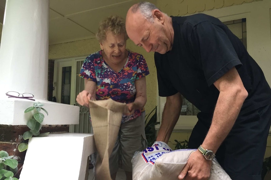 Ros Collins, who has lived in Elwood for 30 years, helps her son Daniel with sandbags as Melbourne braces for a storm.