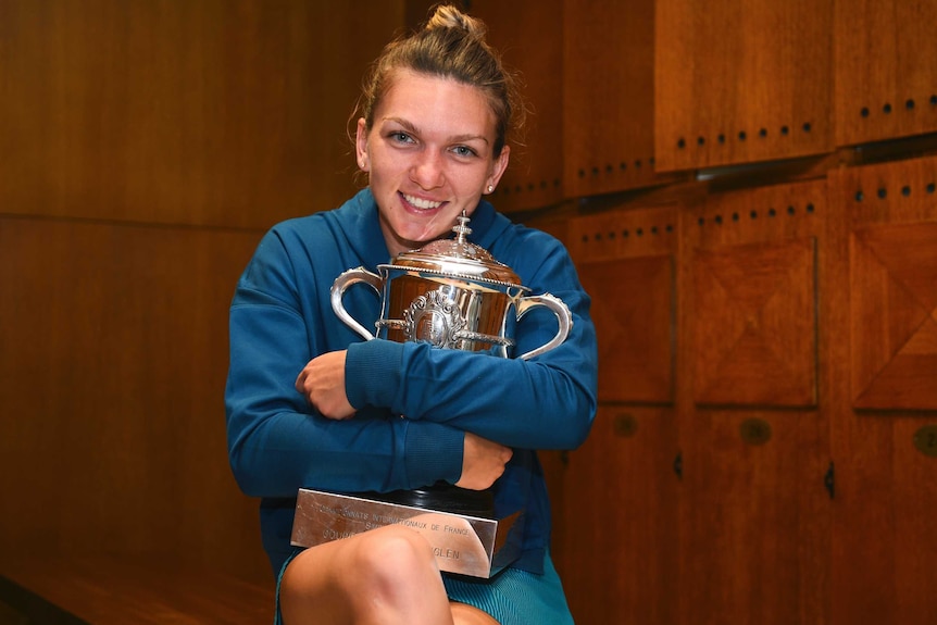 Romania's Simona Halep hugs the trophy for the French Open in the dressing room