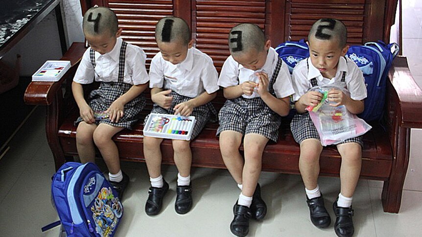 Quadruplets from Shenzhen show off their shaved heads.