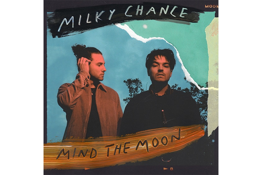 The cover art for Milky Chance's 2019 album Mind The Moon showing the duo sitting in a field