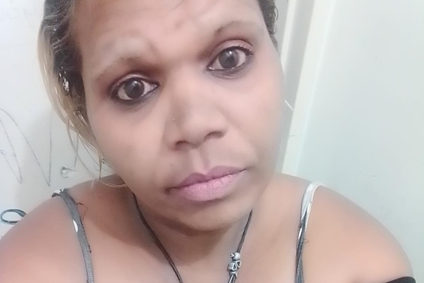 An Aboriginal woman wearing a black top takes a selfie photo.