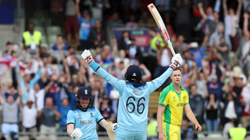 England's Joe Root and Eoin Morgan celebrate their Cricket World Cup semi-final win over Australia. Jason Behrendorff looks on.