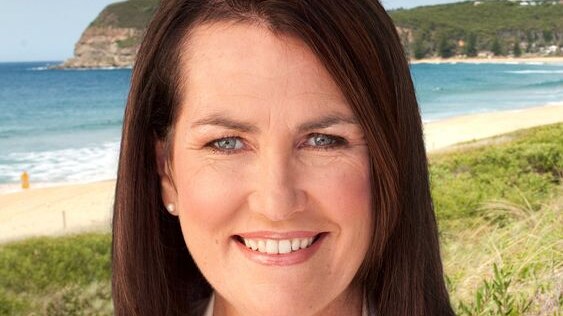A headshot of Deborah O'Neill shows her smiling in front of a beach on a sunny day.
