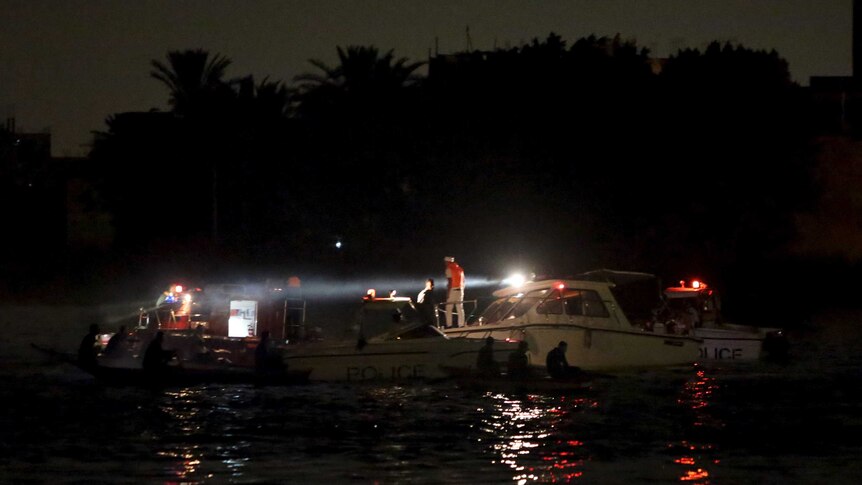 Police boats search for victims of a ferry boat accident on the river Nile in Egypt