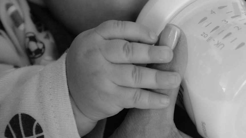 a baby being fed by a bottle