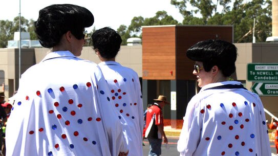 A group of impersonators strut their stuff on stilts at the Parkes Elvis Festival