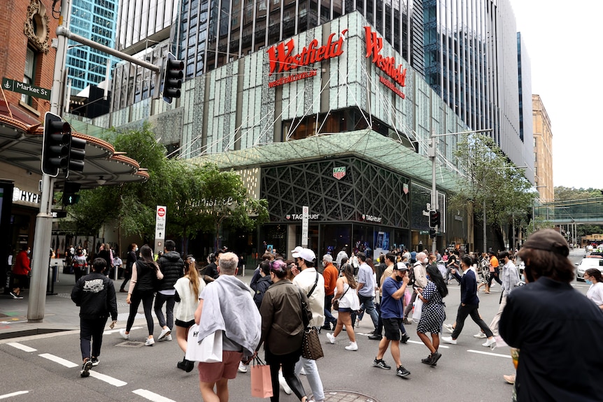 people cross the street on a busy city street