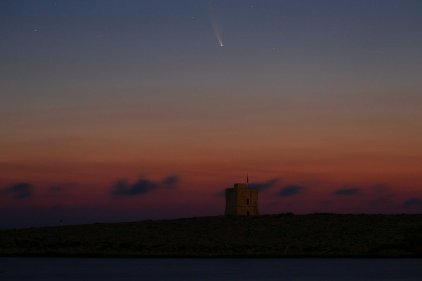 A comet trail is seen in the early morning sky behind St Mark's Tower in Malta