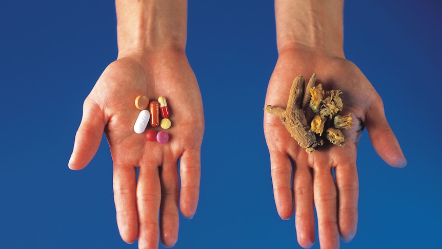 Hands holding pills and herbs separately (Thinkstock: Comstock)