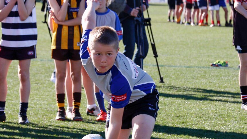 Young player tries out at a football clinic in Hobart