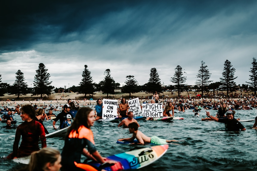 Father and son unite in the first Paddle-out protest in Torquay.