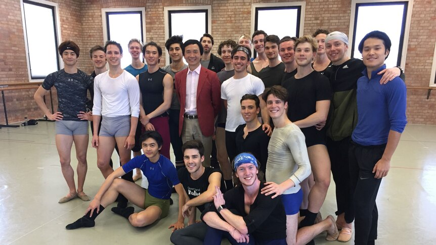 Male ballet dancers and their director pose for a photo