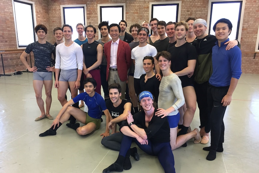 Male ballet dancers and their director pose for a photo