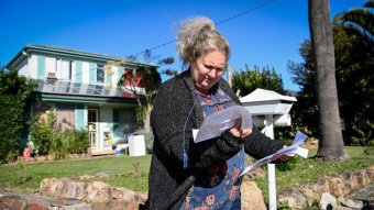 Kim Forrest is seen collecting her mail at home after being sued by A publicly listed debt collection company.