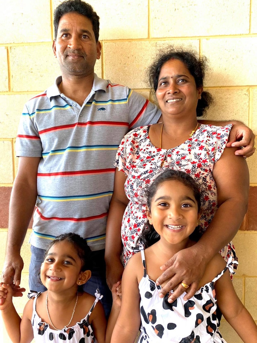 A father and mother with their two daughters.