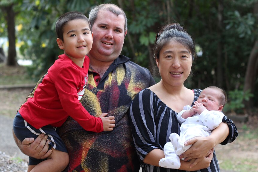 Australian born James Burke and Chinese born Sun Meidong hold their children.