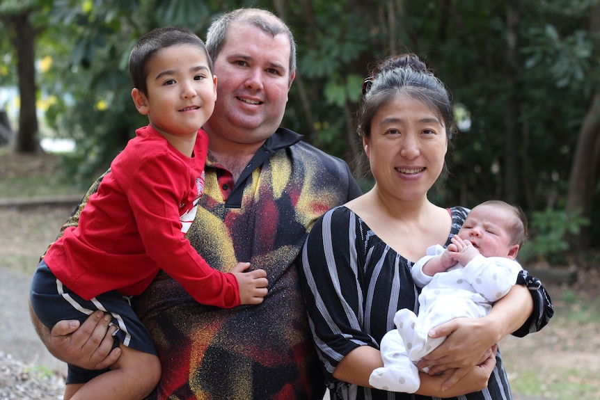 Australian born James Burke and Chinese born Sun Meidong hold their children.