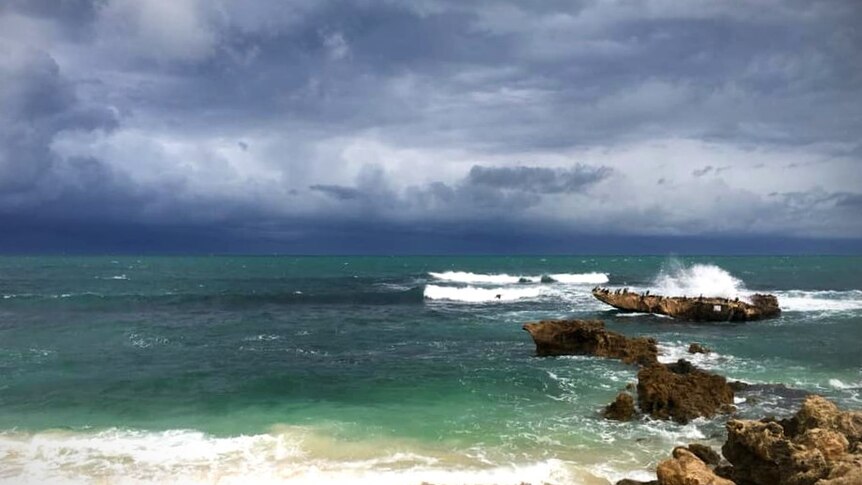 Storm clouds approach an aqua coloured beach