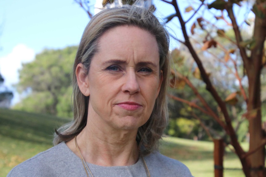 WA Community Services Minister Simone McGurk in an open area with trees and grass in the background.