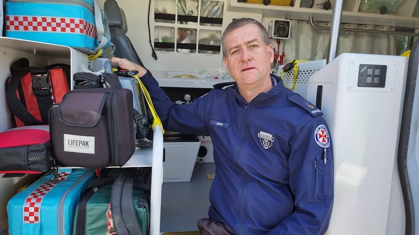 Paramedic sitting next to medical equipment. 