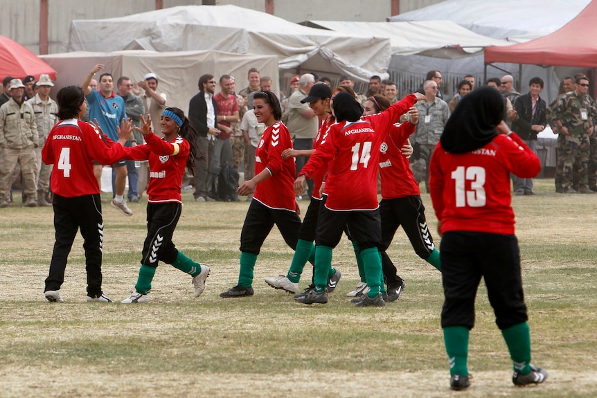 The Afghan national women's soccer team celebrates a victory on the pitch in Kabul, 2010.