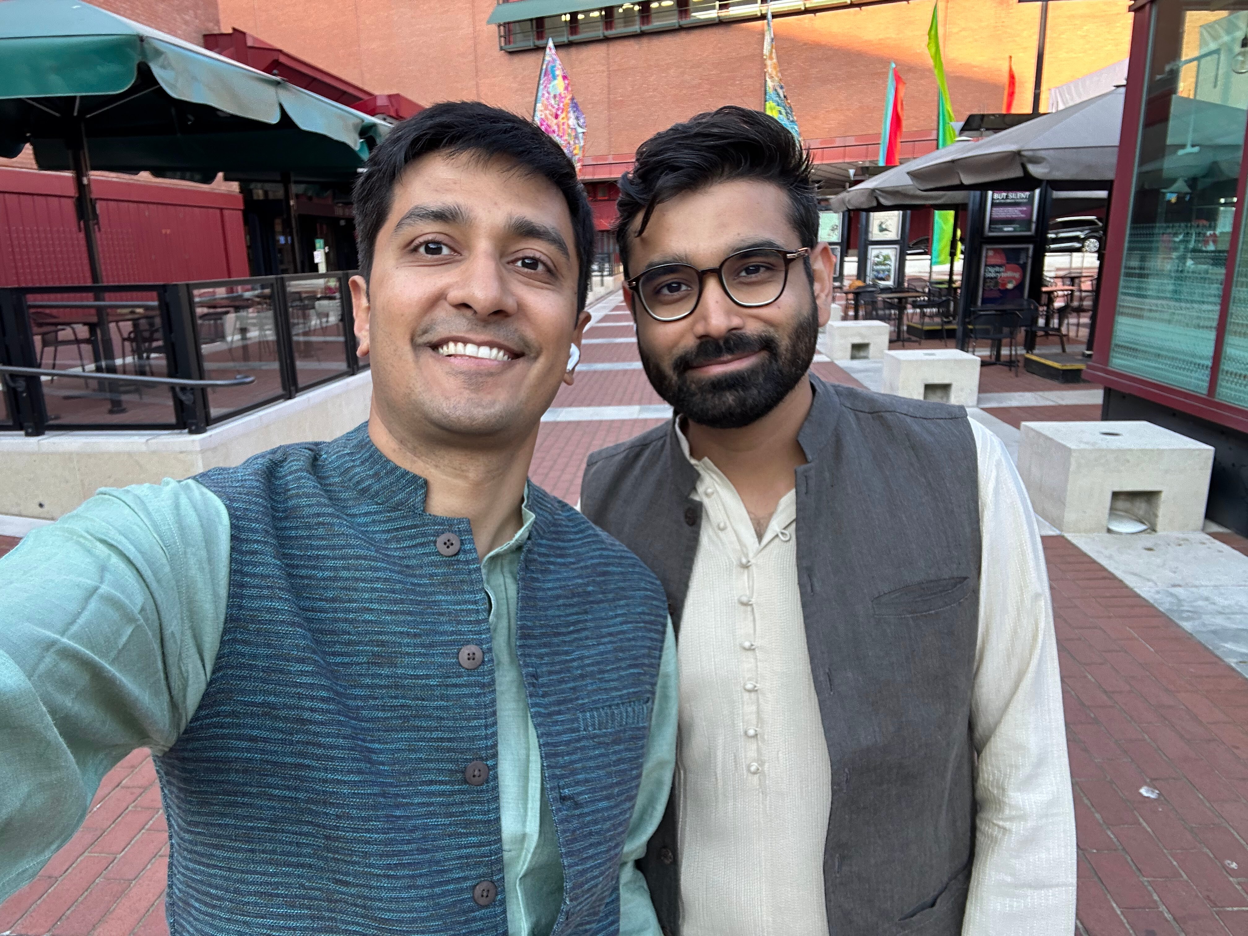 Two men smile at the camera as they take a selfie.
